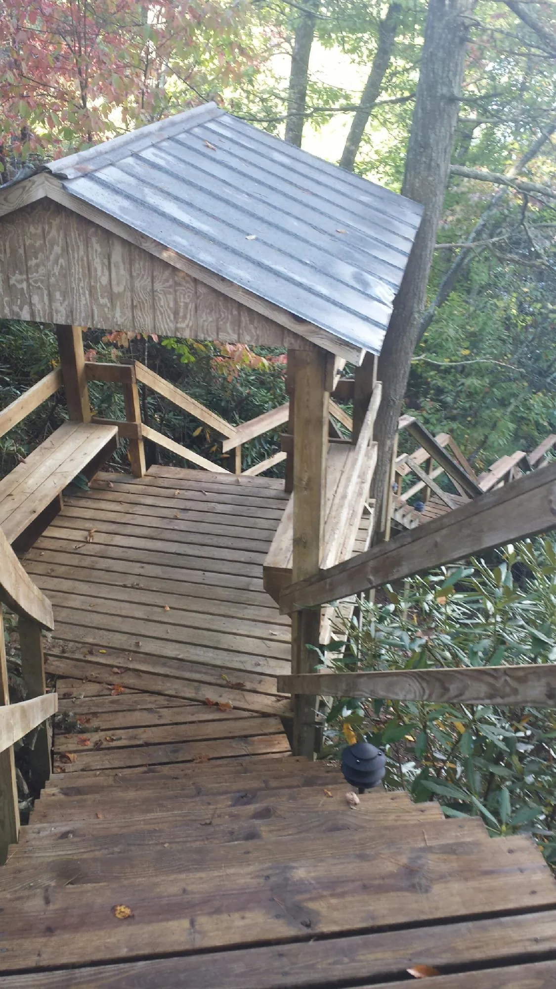 Metal roofed shelter over wooden steps on a wooded walkway — Skylight Repair & Installation work by our crew in Bow